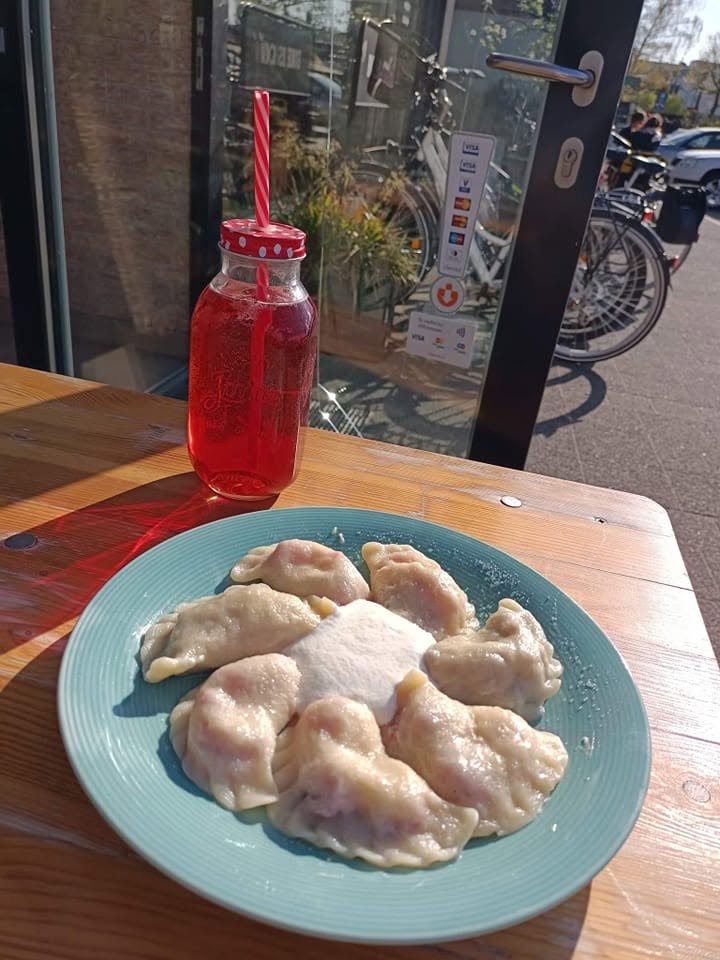 Porcja pierogów na słodko ze śmietaną i kompotem
